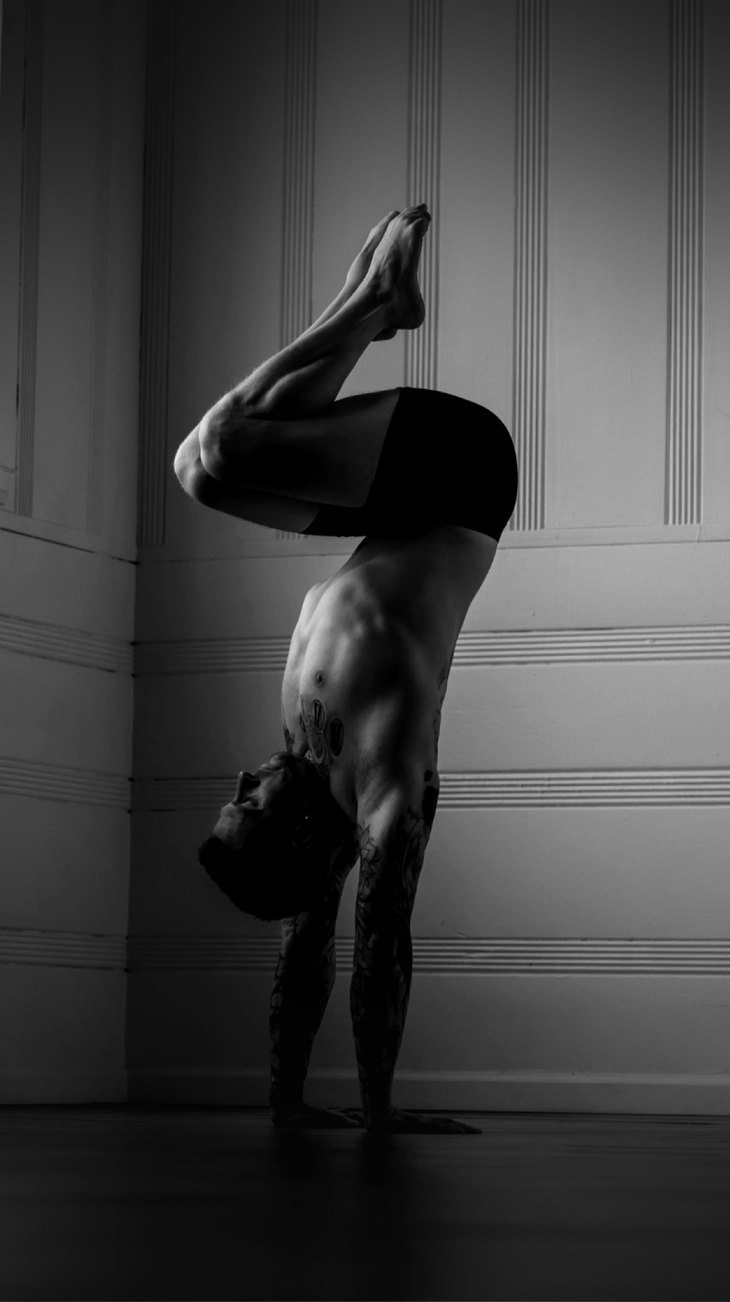 A handstand practitioner in a tucked shape