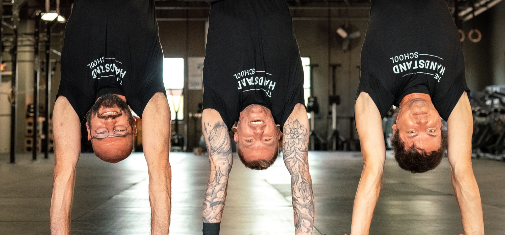 Andrey Moraru, Dr. Robert Adams and Kyle Weiger in handstands